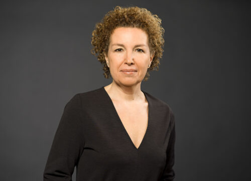 Woman with short brown curls in a black top