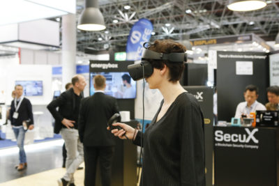 A young woman wearing VR glasses at a trade fair