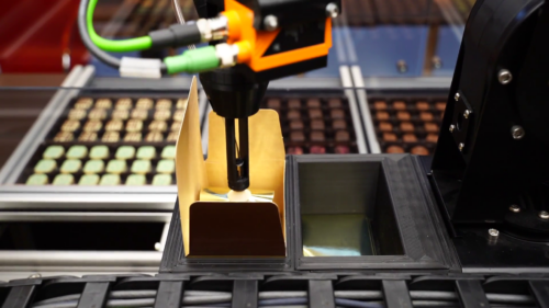 Der Roboterarm legt die Pralinen mit dem Sauggreifer in eine Box; Copyright: igus GmbH