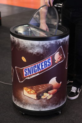 Bild: Runde Säule als Kühlschrank mit Snickers Werbung beklebt; Copyright: iXtenso