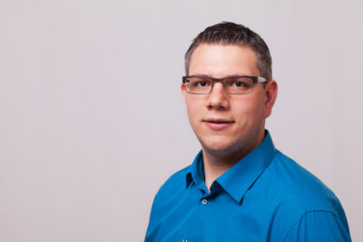 Man in blue shirt with short dark hair and glasses - Michael Urbanek; Copyright: Roqqio
