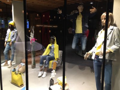 Shop window with sitting and standing mannequins in yellow-blue clothes; copyright: iXtenso/Pott