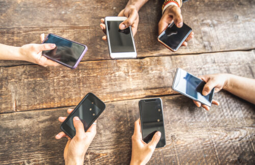 Several smartphones are held above a table; Copyright: AXXEL6 /MirkoVitali