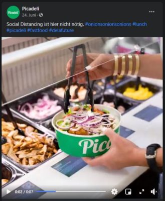 Screenshot of a Facebook video showing a person scooping salad from a counter