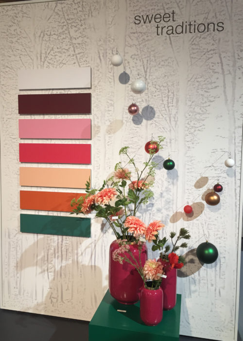 Wall with a colour palette in earth tones with shrub and Christmas tree balls in front; copyright: iXtenso/Pott