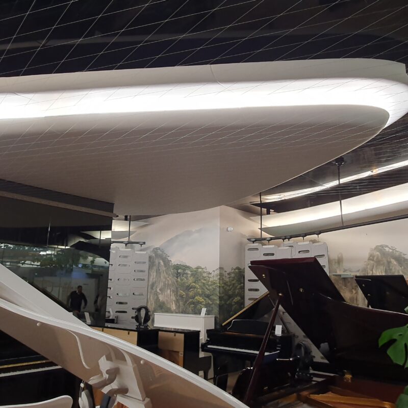 Grand piano strings made of stainless steel cable adorn the ceiling; Copyright: EuroShop/Pott