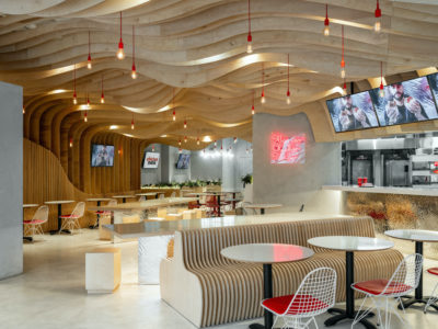 A modern fast food restaurant with wavy wood panels at the ceiling