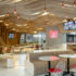 A modern fast food restaurant with wavy wood panels at the ceiling