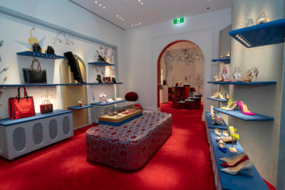 A luxury shoe boutique with blue velvet shoe shelves