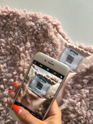 Ein Smartphone scannt ein etikett in einem Kleidungsstück