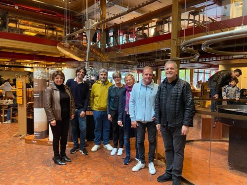 Seven people stand side by side for a photo in the chocolate factory