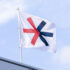Die EuroShop-Flagge weht im Wind auf dem Dach einer Messehalle vor blauem Himmel; Copyright: Messe Düsseldorf/Wiese