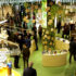 A large booth at EuroShop 2023 in green with many visitors