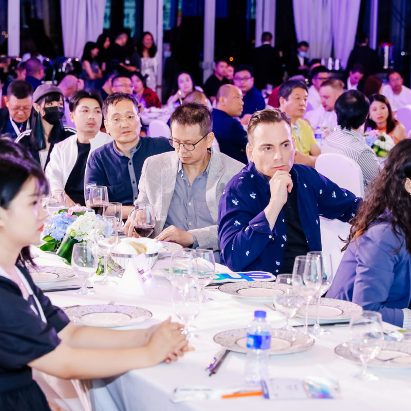 Eine Veranstaltungshalle in Shanghai mit vielen Gästen an Tischen