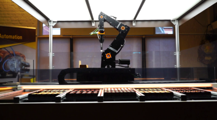 Der Roboterarm ist über der Auslage der Pralinen platziert; Copyright: igus GmbH