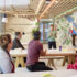 Mehrere Personen sitzen bei einem Workshop zusammen, im Hintergrund steht "Google Zukunftswerkstatt" an der Wand