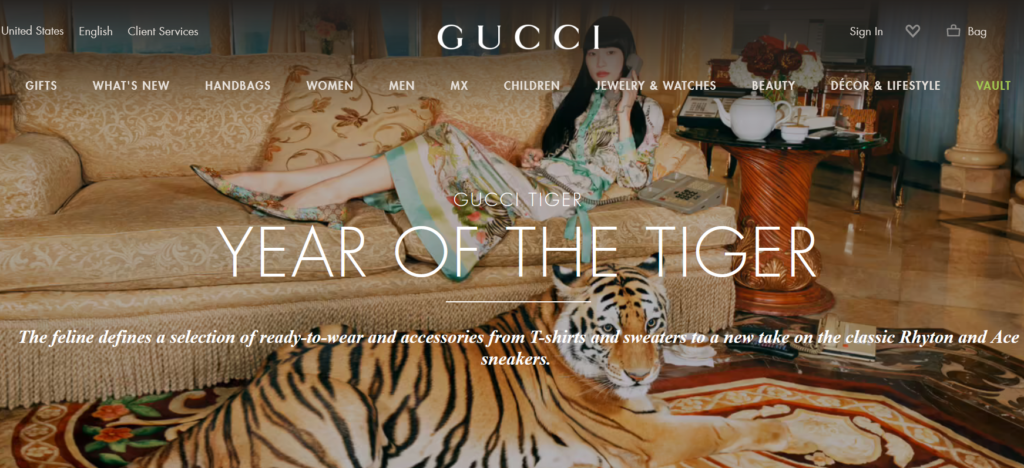 Screenshot des Onlineshops von Gucci mit einer Frau auf einer Couch, davor liegt ein echter Tiger