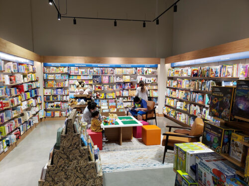 a branch of the bookseller Barnes & Noble with book shelves and book tables and a children's play corner