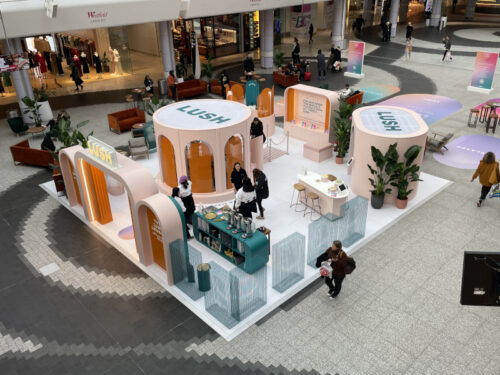 Eine Lush-Pop-up-Area in der Eingangshalle eines Einkaufszentrums mit Theken und Sitzgelegenheiten
