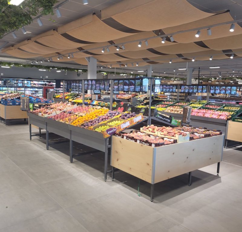 An open vegetable and fruit department with merchandise tables in the louis delhaize OPEN MARKET