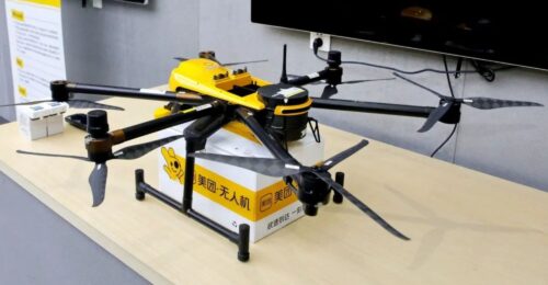 Eine Drohne mit einem Paket steht auf einem Tisch