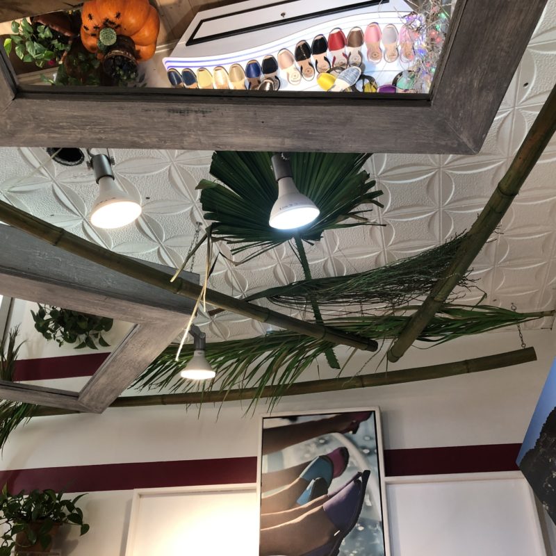 Mirror, palm fronds and lights mounted on a ceiling