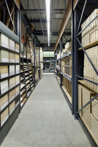 An aisle with high shelves on the right and left in the hardware store; copyright: Tegometall