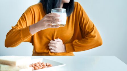 Woman having a stomach pain with a glass of milk at home,Allergy dairy intolerant,Lactose intolerance concept