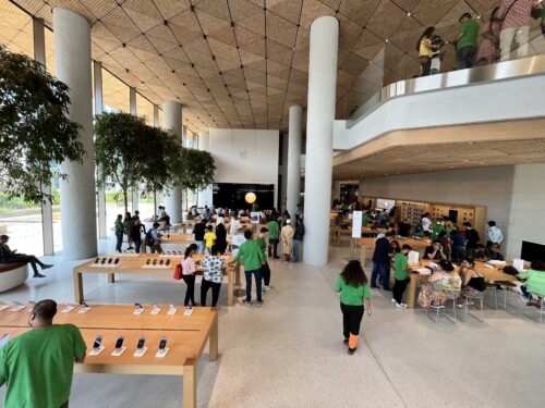 The interior of a large modern building with tables and people