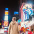 A person stands in front of the billboards at Time Square; Copyright: Joshua Earle / Unsplash