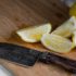 Geschnittene Zitrone auf einem Holzbrett mit Messer; copyright: unsplash