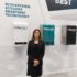 A woman standing at a trade fair stand infront of small refrigeration units; copyright: beta-web GmbH/Saeed