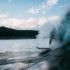 Mann, der mit seinem Surfbrett aug dem Meer eine Welle reitet