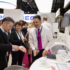 Asian visitors at a trade fair smiling and looking at products; copyright: Koelnmesse GmbH, IDS, Harald Fleissner