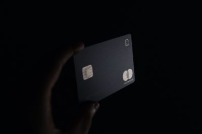 Schwarze Kreditkarte halb im Schatten; copyright: Unsplash/Ales Nesetril