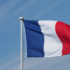 Französische Flagge weht im Wind, im Hintergrund ein blauer Himmel