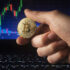 Golden Bitcoin in front of a Trading-Chart-Background; Copyright: PantherMedia / Dusan Zidar