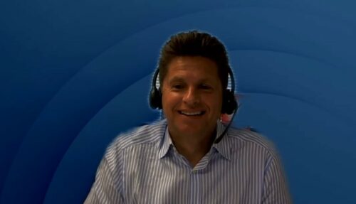 Ein Mann mit Kopfhörern vor blauem Hintergrund