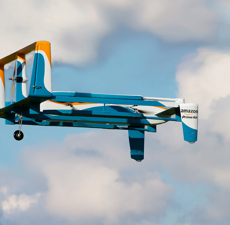 Blue, white, orange Prime Air drone in the air; Copyright: Amazon
