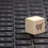 A little wooden block with a shopping cart symbol sitting on the keypad of a computer